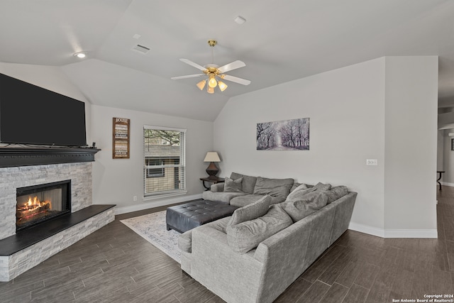 living room featuring dark wood-type flooring, vaulted ceiling, ceiling fan, and a fireplace