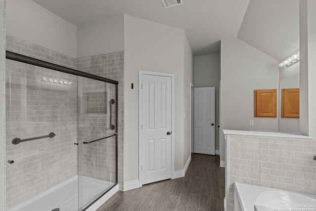 bathroom featuring independent shower and bath, wood-type flooring, and vaulted ceiling