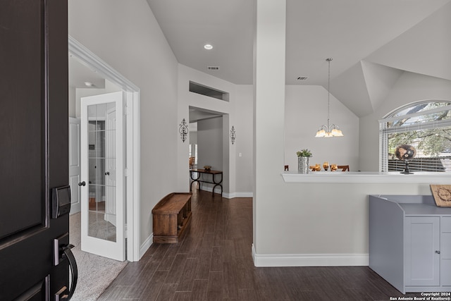 interior space featuring vaulted ceiling, pendant lighting, dark hardwood / wood-style flooring, and a notable chandelier