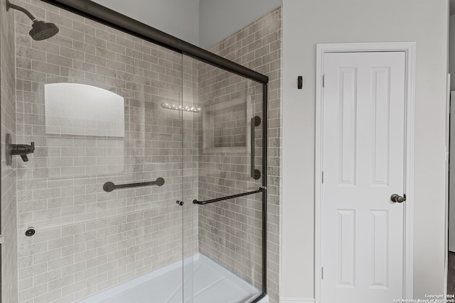 bathroom featuring a shower with shower door