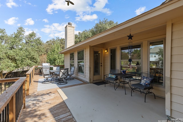 wooden terrace with ceiling fan and area for grilling