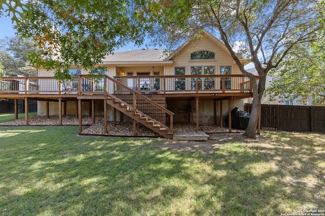 rear view of house featuring a lawn and a wooden deck