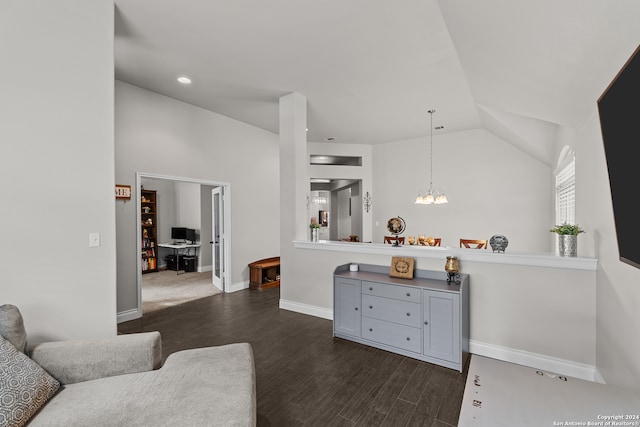 living room featuring dark hardwood / wood-style floors, lofted ceiling, and a notable chandelier