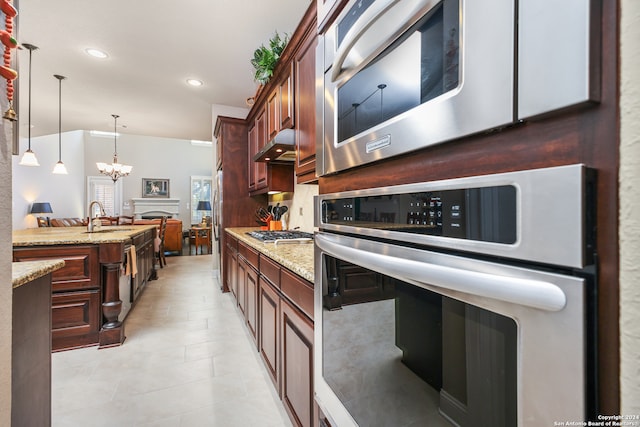 kitchen featuring extractor fan, appliances with stainless steel finishes, pendant lighting, sink, and an inviting chandelier