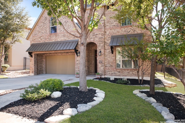 view of front of property featuring a garage and a front lawn