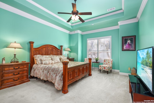 carpeted bedroom featuring a tray ceiling, ceiling fan, and crown molding