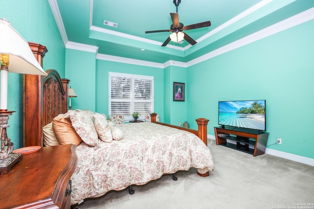 carpeted bedroom with a tray ceiling, ceiling fan, and crown molding