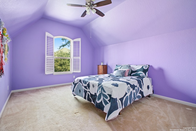 bedroom featuring ceiling fan, a textured ceiling, light carpet, and vaulted ceiling