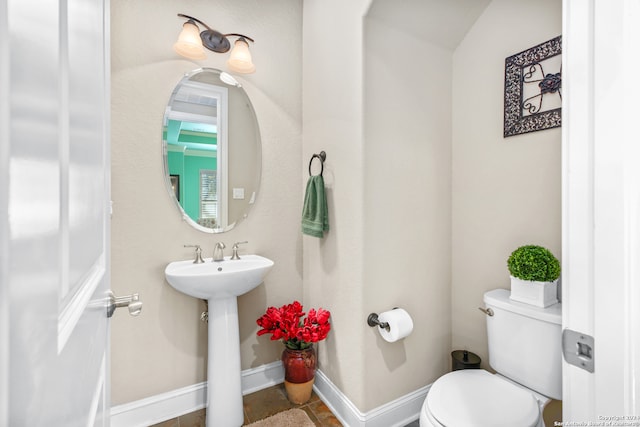 bathroom featuring lofted ceiling, sink, and toilet