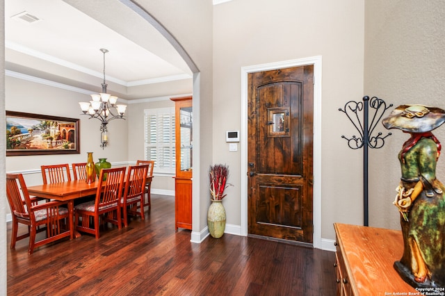 dining area featuring a chandelier, a tray ceiling, dark hardwood / wood-style floors, and crown molding