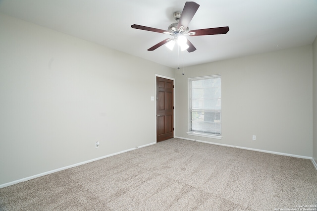 carpeted spare room with ceiling fan