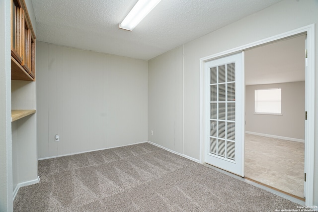 spare room featuring carpet flooring and a textured ceiling