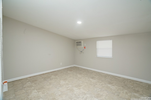 unfurnished room featuring an AC wall unit