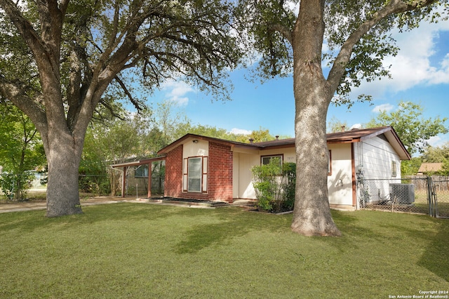 view of front of house with central AC unit and a front yard