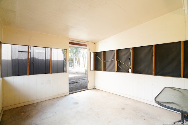 unfurnished room featuring concrete flooring and vaulted ceiling