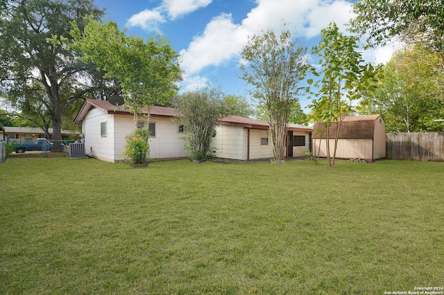 view of yard featuring central air condition unit and a storage unit