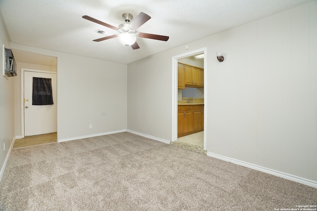 carpeted empty room with a textured ceiling and ceiling fan