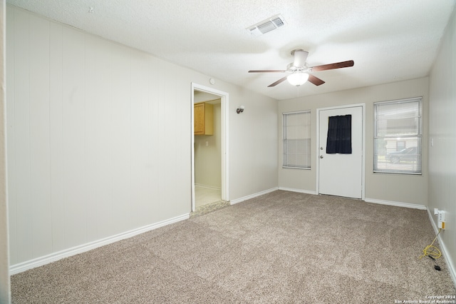 spare room featuring ceiling fan, a textured ceiling, and carpet flooring