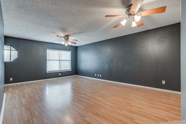 spare room with a textured ceiling, ceiling fan, and light hardwood / wood-style flooring