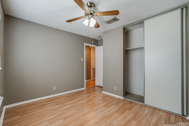 unfurnished bedroom featuring light wood-type flooring, a textured ceiling, and ceiling fan