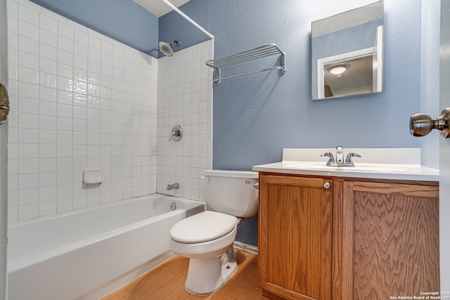 full bathroom featuring vanity, wood-type flooring, tiled shower / bath, and toilet