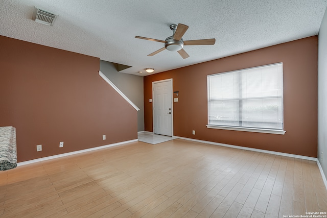 interior space featuring light hardwood / wood-style floors, ceiling fan, and a textured ceiling