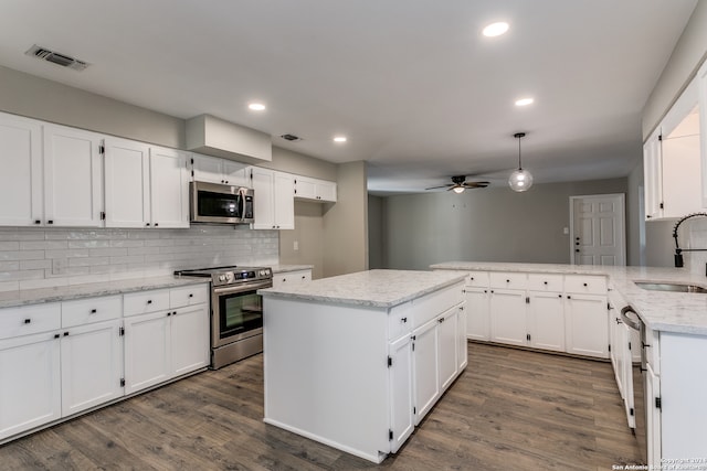 kitchen featuring white cabinetry, sink, hanging light fixtures, dark hardwood / wood-style flooring, and appliances with stainless steel finishes