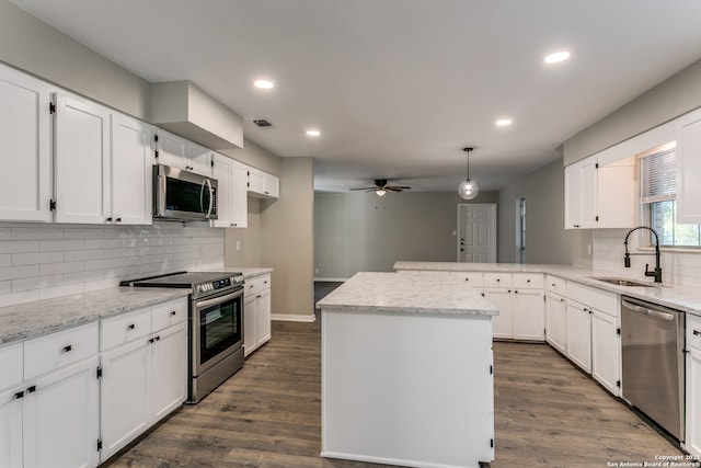 kitchen with dark hardwood / wood-style floors, a center island, white cabinetry, and appliances with stainless steel finishes