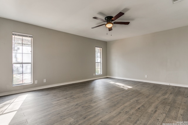 empty room with hardwood / wood-style flooring, ceiling fan, and a healthy amount of sunlight