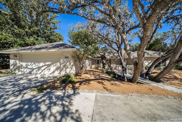 4103 Midvale Dr, San Antonio, TX 78229 - view of front facade featuring brick siding, concrete driveway, and a garage