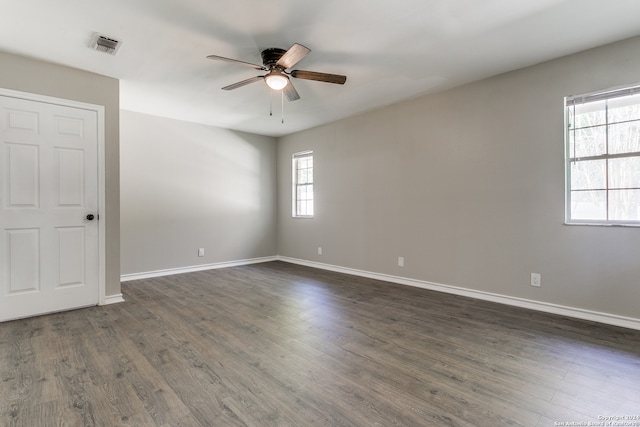 empty room featuring dark hardwood / wood-style floors, plenty of natural light, and ceiling fan