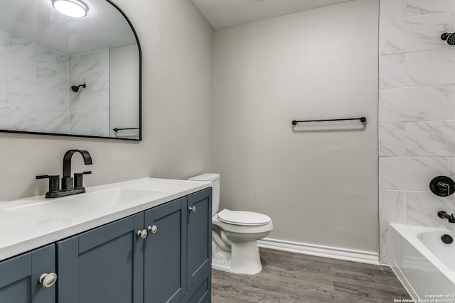 full bathroom featuring hardwood / wood-style floors, vanity, toilet, and tiled shower / bath