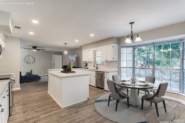 4103 Midvale Dr, San Antonio, TX 78229 - kitchen featuring stainless steel appliances, a center island, a sink, white cabinetry, and wood finished floors