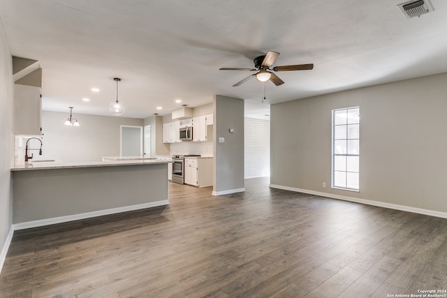 unfurnished living room with ceiling fan with notable chandelier, dark hardwood / wood-style flooring, and sink