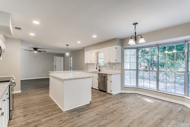 kitchen featuring appliances with stainless steel finishes, sink, pendant lighting, wood-type flooring, and white cabinetry