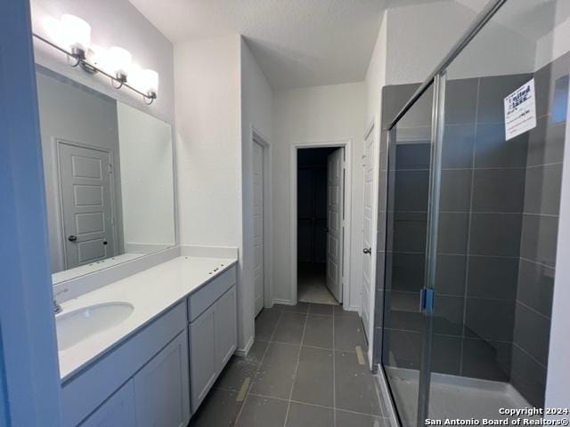 bathroom featuring vanity, tile patterned floors, and walk in shower