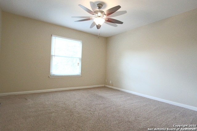 spare room featuring ceiling fan and carpet flooring