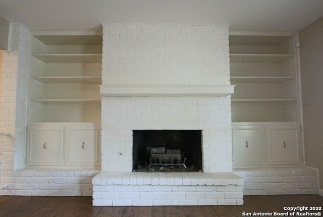 details featuring a fireplace, hardwood / wood-style flooring, and built in shelves