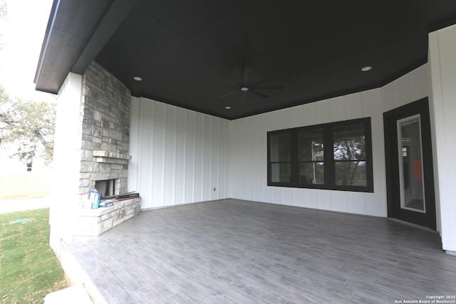 view of patio / terrace with an outdoor stone fireplace, a deck, and ceiling fan