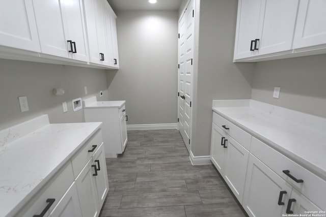 washroom with cabinets, washer hookup, and dark hardwood / wood-style flooring