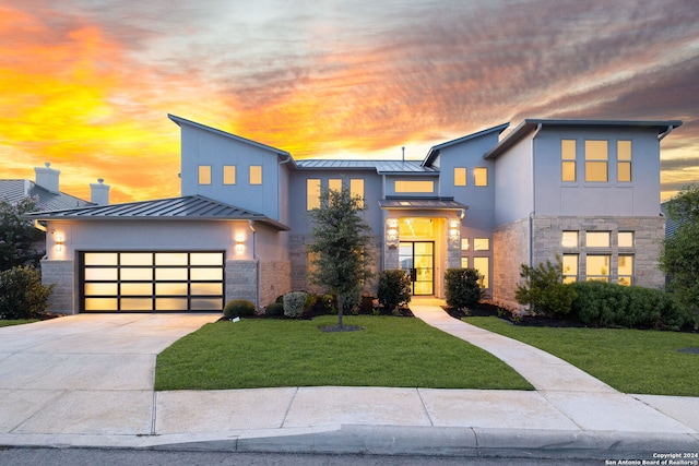 contemporary home featuring a garage and a yard