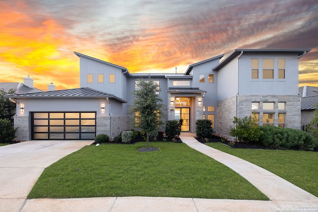 contemporary house featuring a garage and a yard