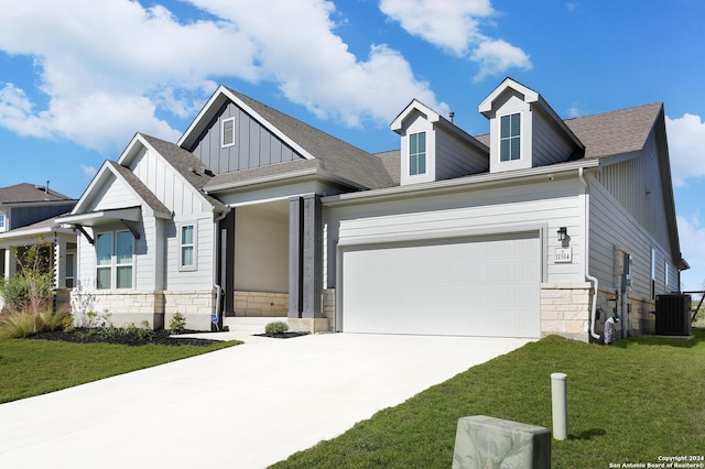 11514 Hollering Pass, Schertz, TX 78154 - view of front facade with stone siding, board and batten siding, concrete driveway, an attached garage, and central air condition unit
