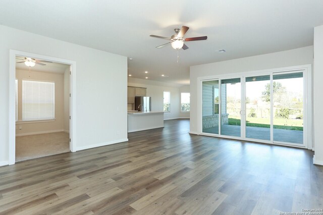 11514 Hollering Pass, Schertz, TX 78154 - unfurnished living room featuring ceiling fan, baseboards, wood finished floors, and recessed lighting