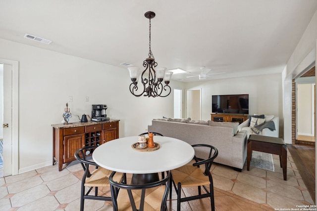 dining room featuring light tile patterned floors and ceiling fan with notable chandelier