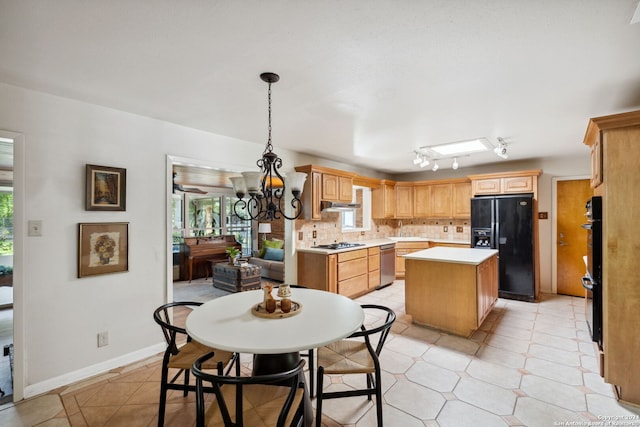 kitchen with black appliances, decorative backsplash, light tile patterned floors, decorative light fixtures, and a kitchen island