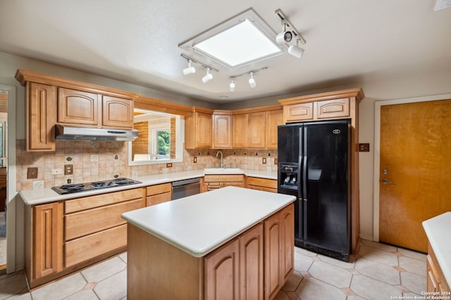 kitchen with gas cooktop, black fridge, sink, dishwasher, and a kitchen island