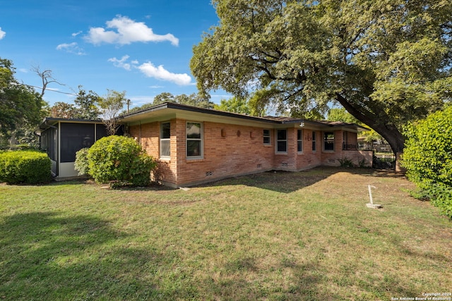 exterior space featuring a lawn and a sunroom