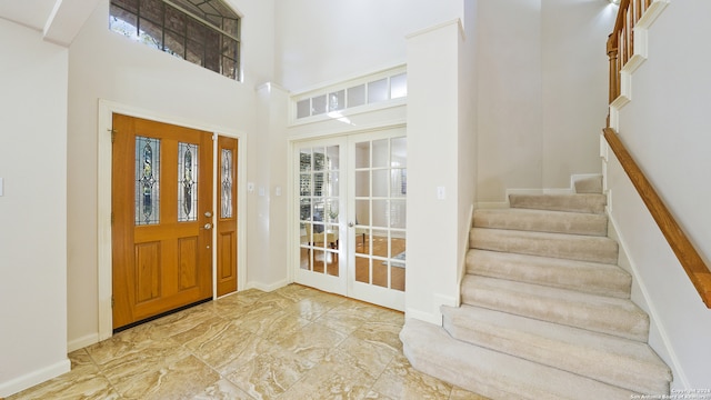 entrance foyer featuring a towering ceiling and french doors