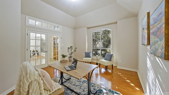 sitting room with french doors, hardwood / wood-style floors, and a raised ceiling